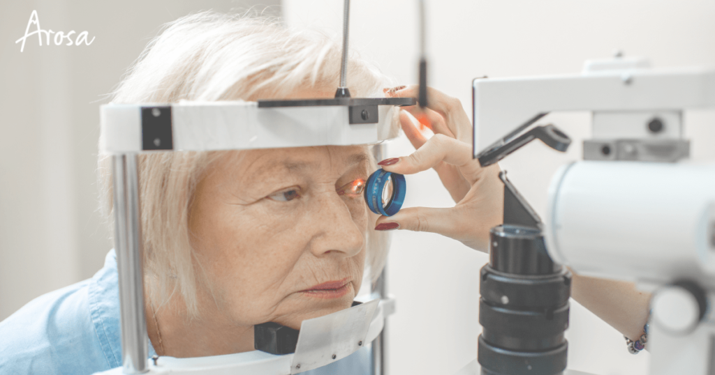 Picture of a senior citizen getting her eyes examined with a device by a doctor.