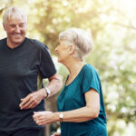 Senior couple smiling during a heart health consultation about long-term care planning and in-home support.