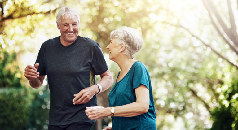 Senior couple smiling during a heart health consultation about long-term care planning and in-home support.
